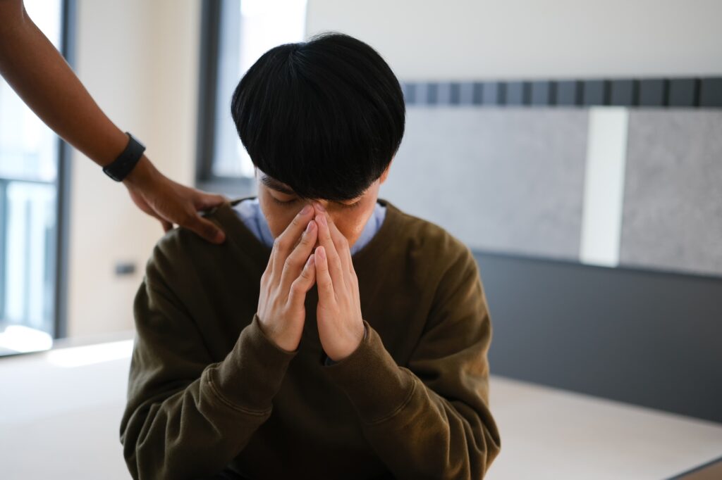 Caring friend touching shoulder comforting depressed man, expressing trust and support.