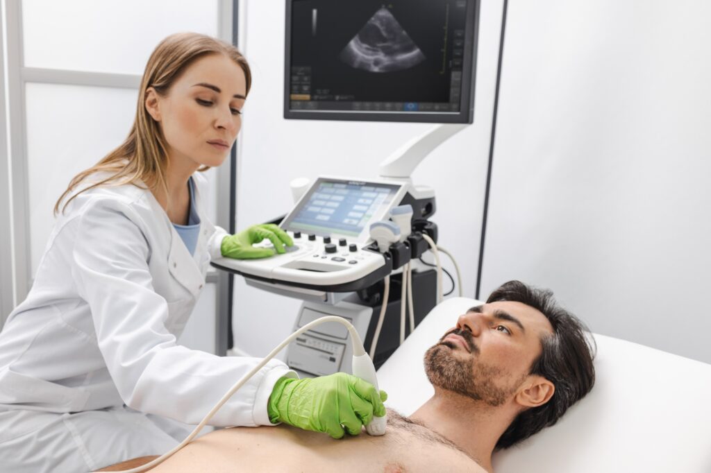 Heart ultrasound exam for adult man with ultrasound specialist while medical exam at hospital