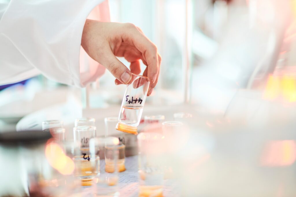 Labratory scientist extracting dna and biological material for testing from test tube on his desk