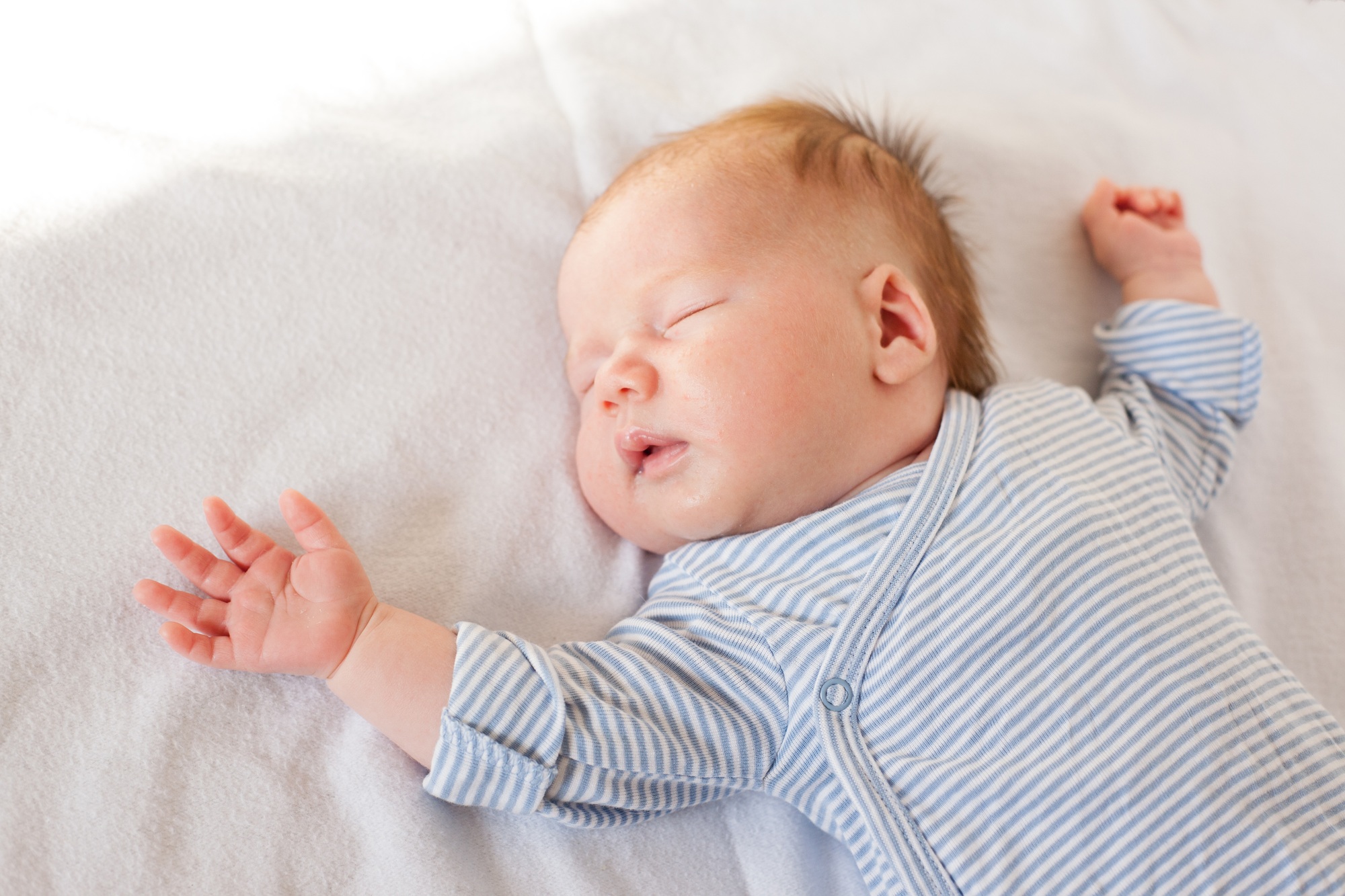 newborn baby one month sleeps on the bed.